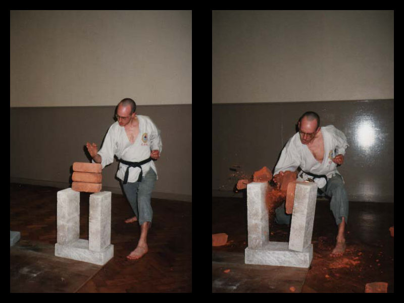 Simon: at his Wu Shu Kwan black belt grading; preparing to chop bricks with his hand, and then an action shot as he chops through the bricks.